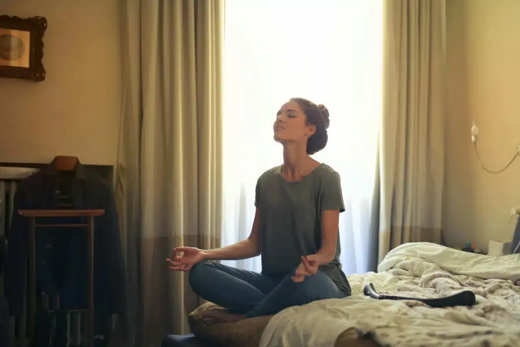 Woman Meditating In Bedroom
